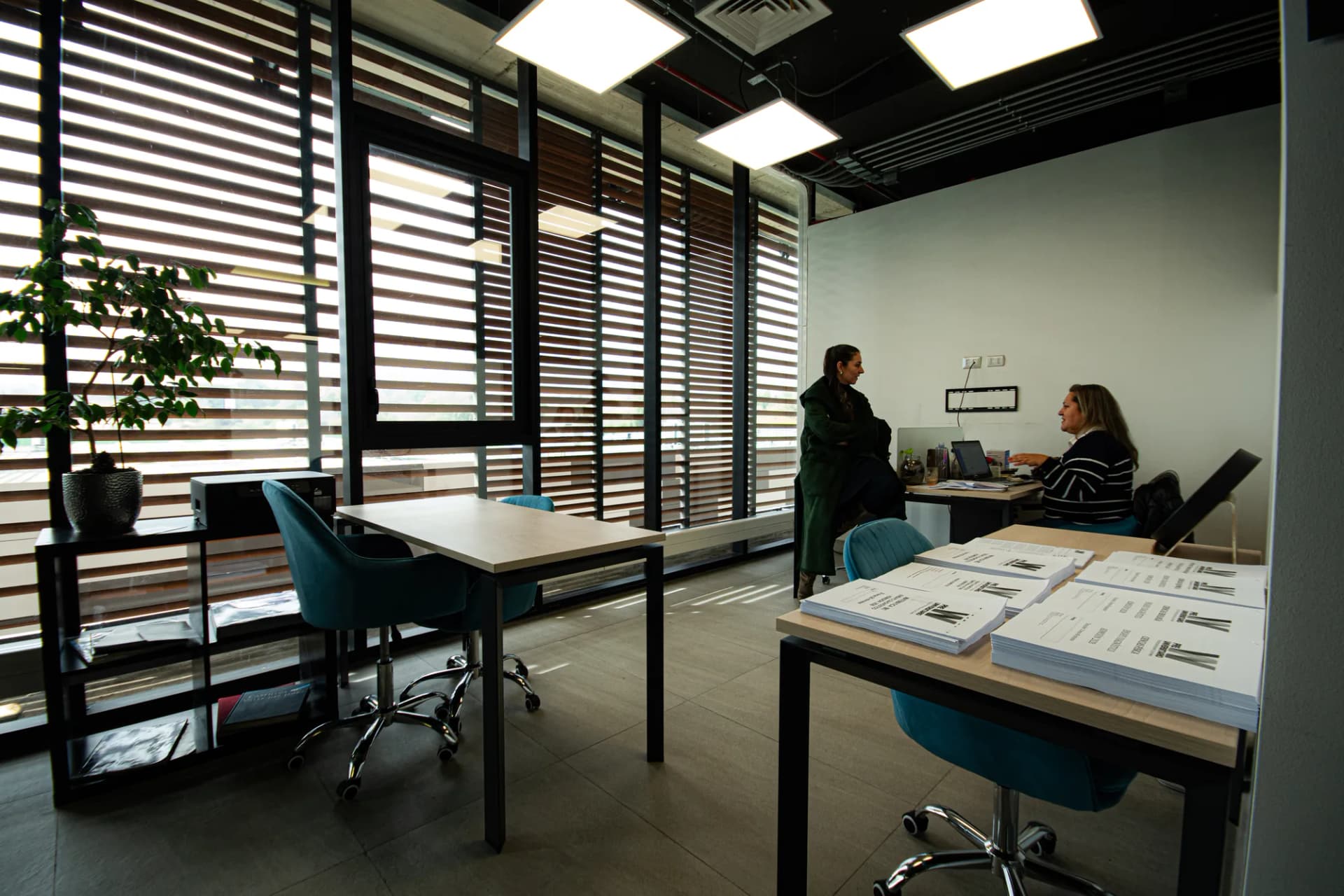Oficina privada en uso, con escritorios y luz natural